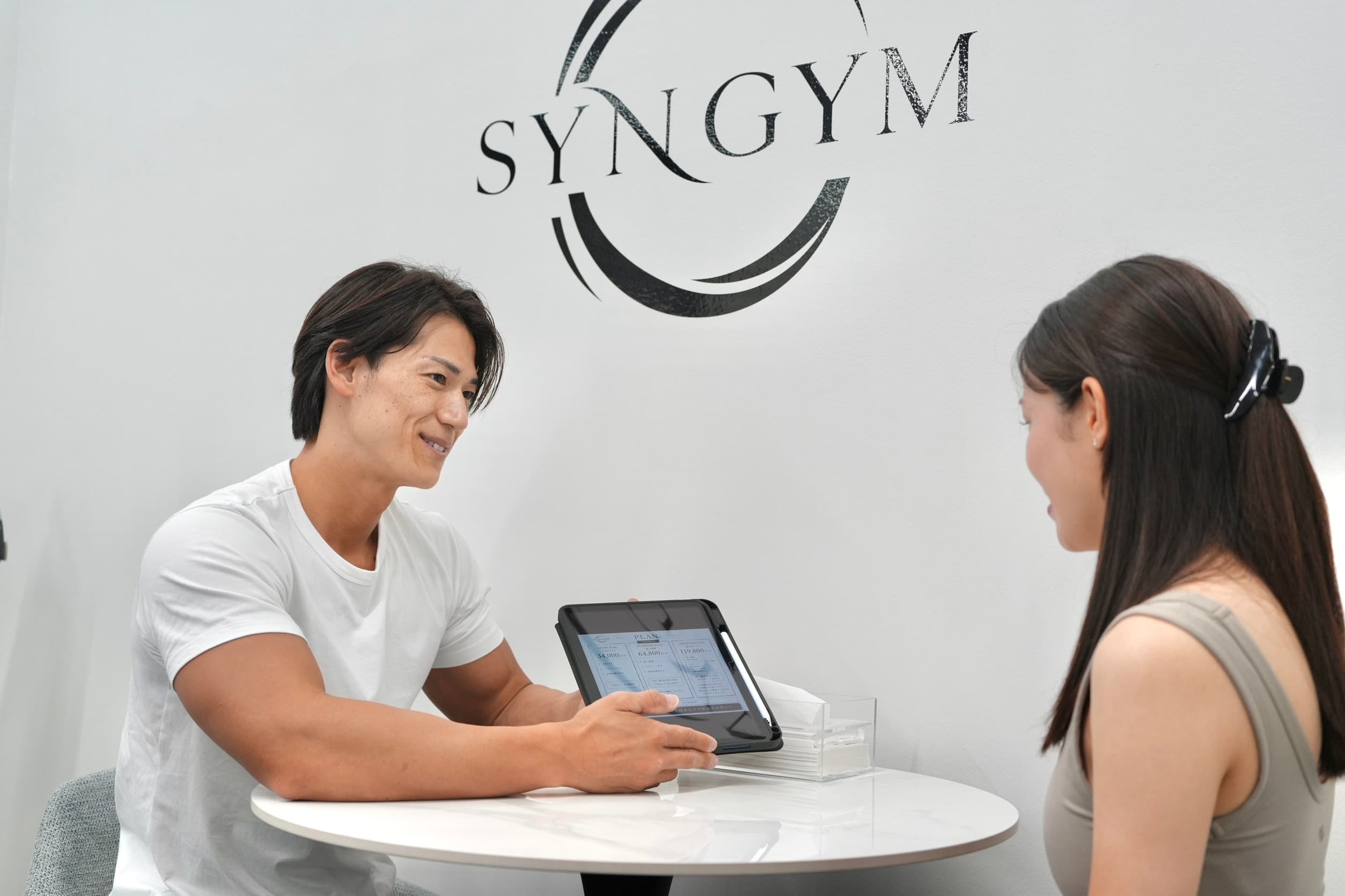 SYNGYMでカウンセリングを行うトレーナーと利用者